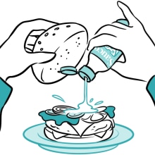 Hands pouring sauce into a hamburger