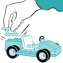 Hand adding a spoiler to a lego car