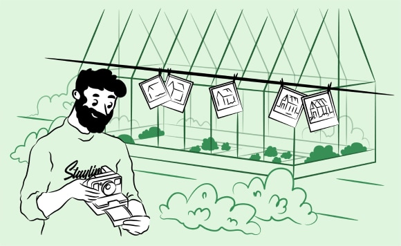 A man taking Polaroid photos of a greenhouse