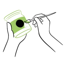 A hand painting a jar